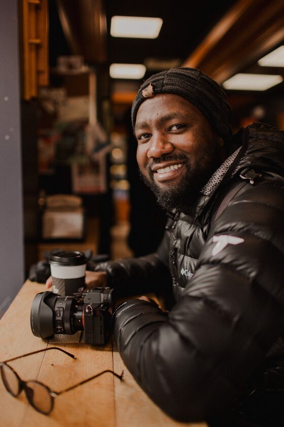 Portrait of Lionel Kanyowa smiling in a cafe