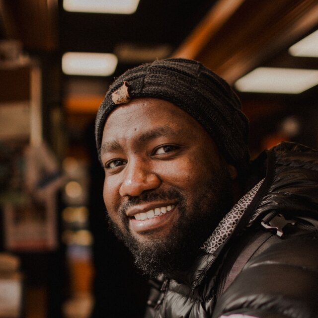 Portrait of Lionel Kanyowa smiling in a cafe
